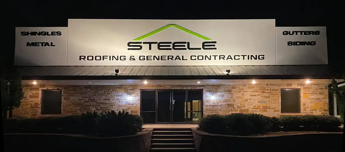 The Steele Roofing and General Contracting office on Hwy 69 South at night, its sign lit
