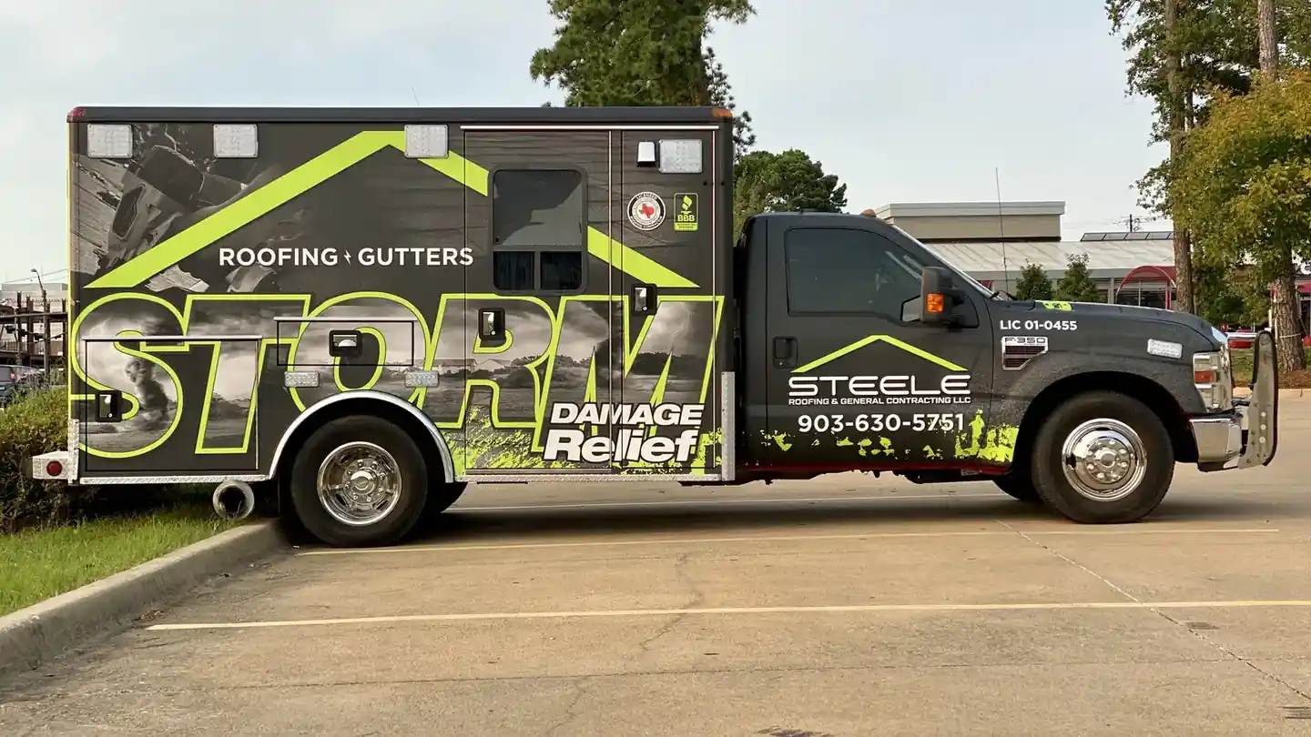 Steele Roofing's black STORM Damage Relief box truck in the lime-green wrap, parked in Tyler